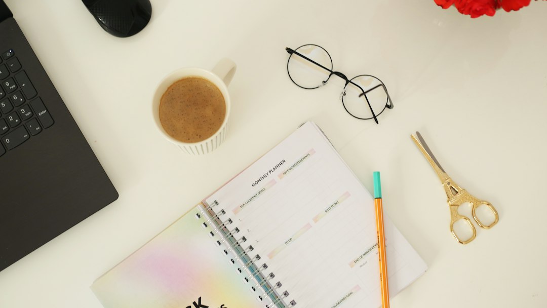 Weekly planner, laptop and stationery on a desk