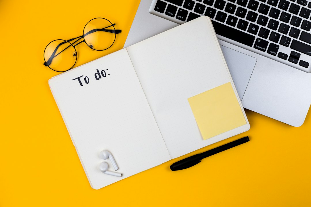 Notebook, laptop and glasses on a bright yellow workspace