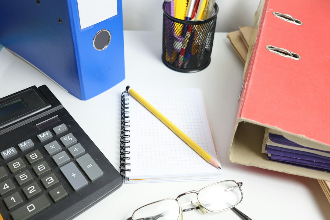 Calculator, notebook and organised accounting files on a desk